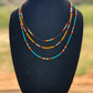 A western style 3 strand necklace. black, yellow, and turquoise serape patterns. 16 inches is the shortest strand, middle strand 18 inches and longest strand is 22 inches. This is cowgirl jewlery